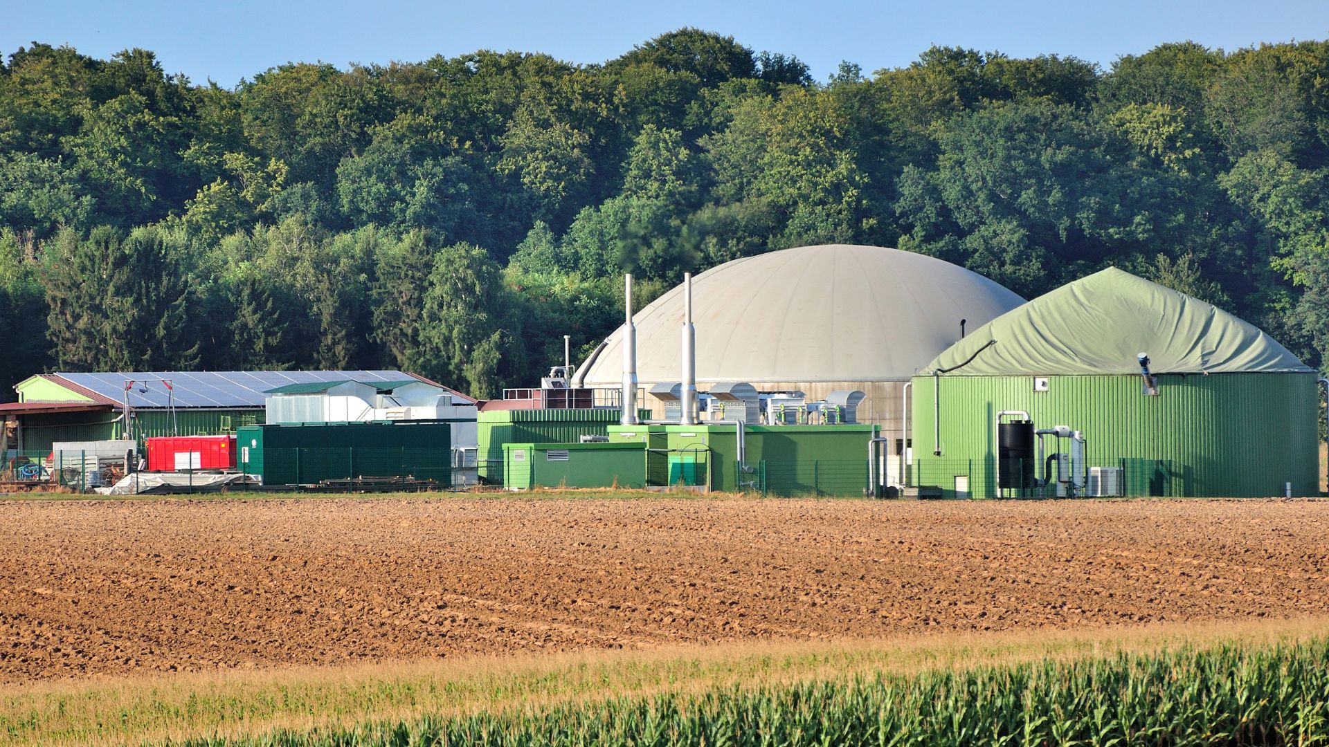 BioCNG plant with digesters, storage tanks, and trucks